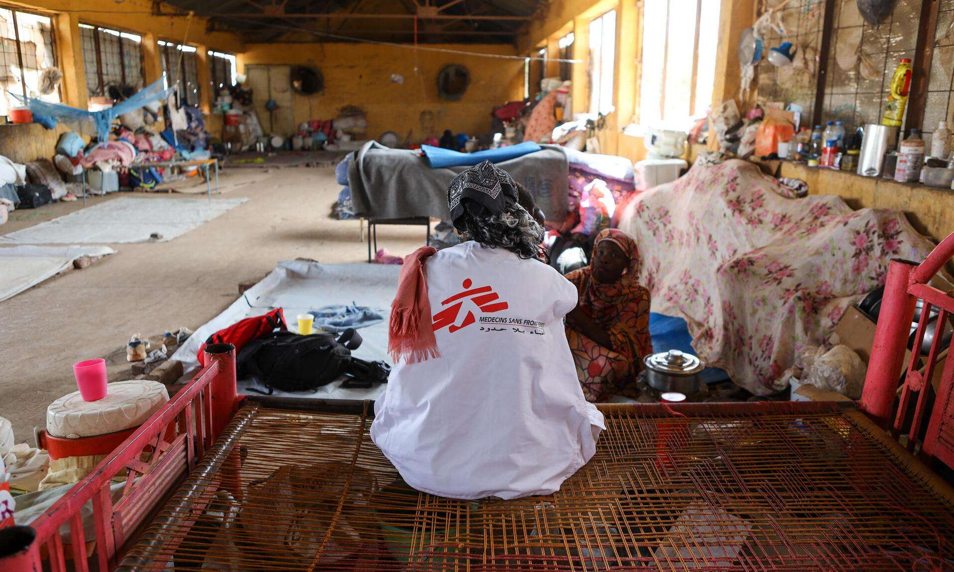 The back of an MSF staff member sitting in a room in Wad Madani, Sudan.