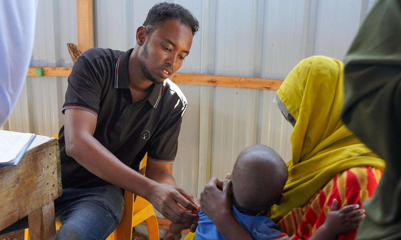 Health care worker measuring arm circumference of a child in Baidoa, Somalia