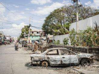 The burned husk of a car on the streets of Port-au-Prince, Haiti. 