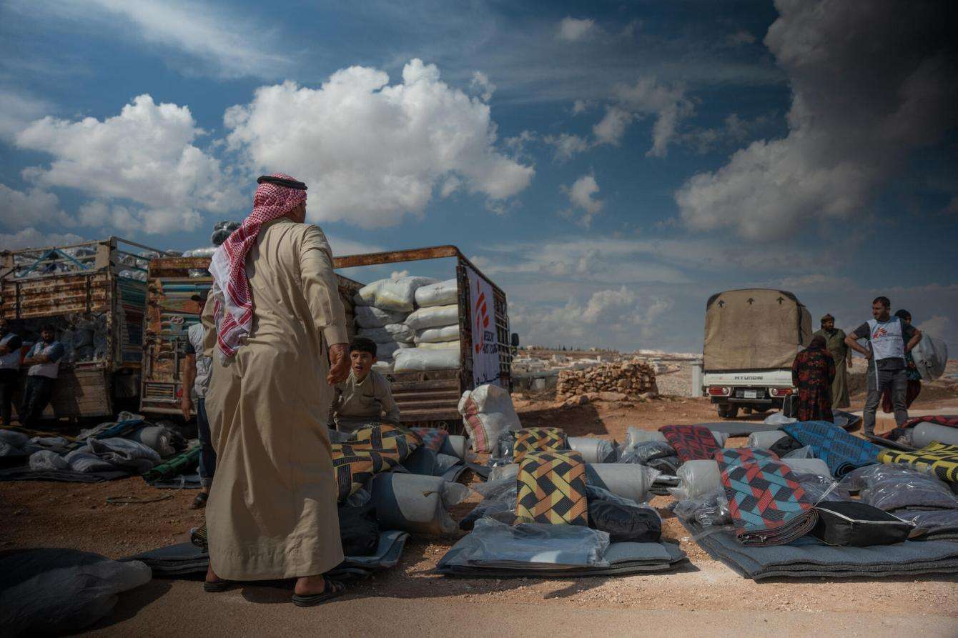 A man looks at trucks carrying winter supplies donated by MSF in Syria.