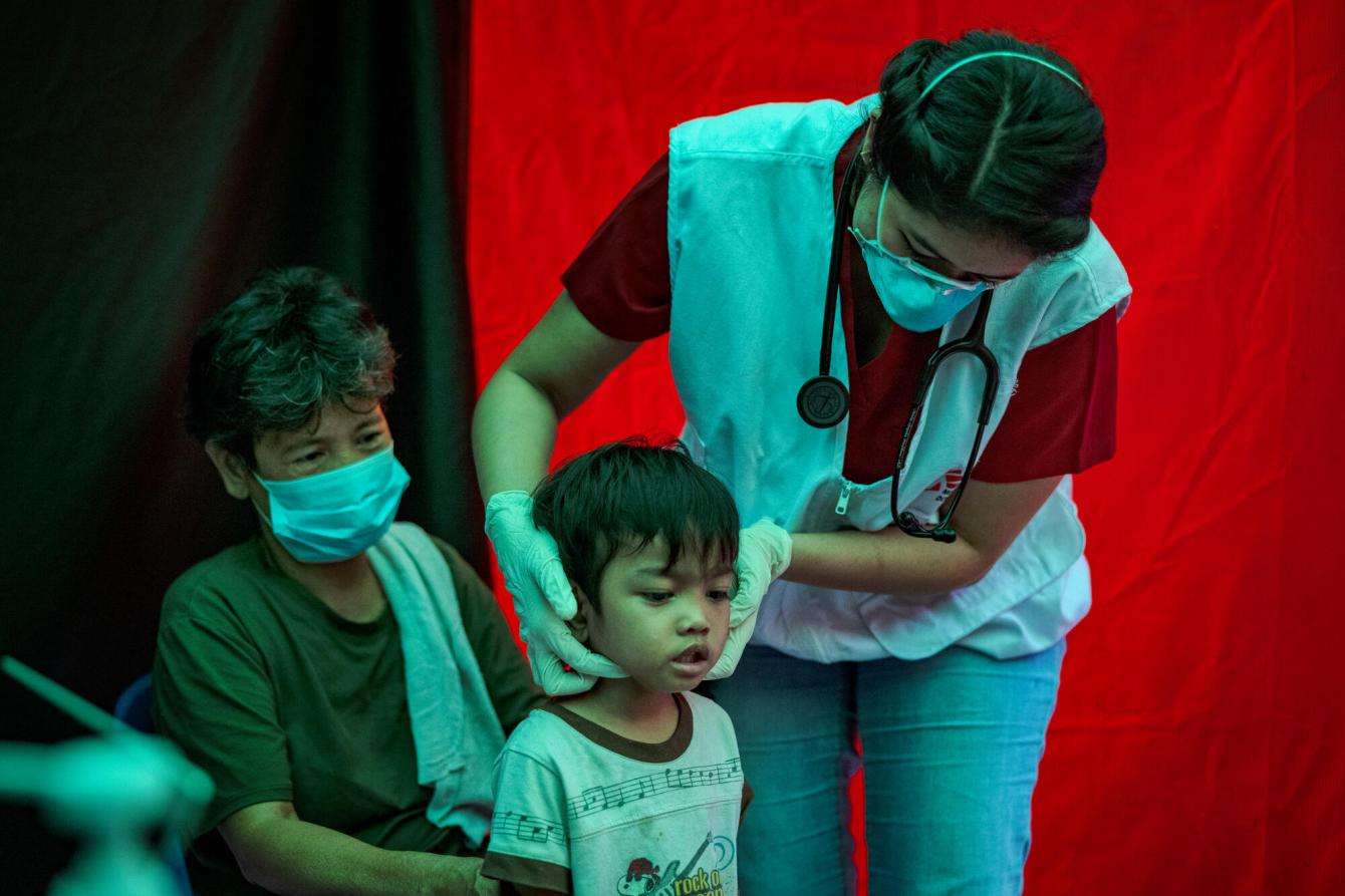 An MSF staff member assesses a child for tuberculosis in Manila, Philippines