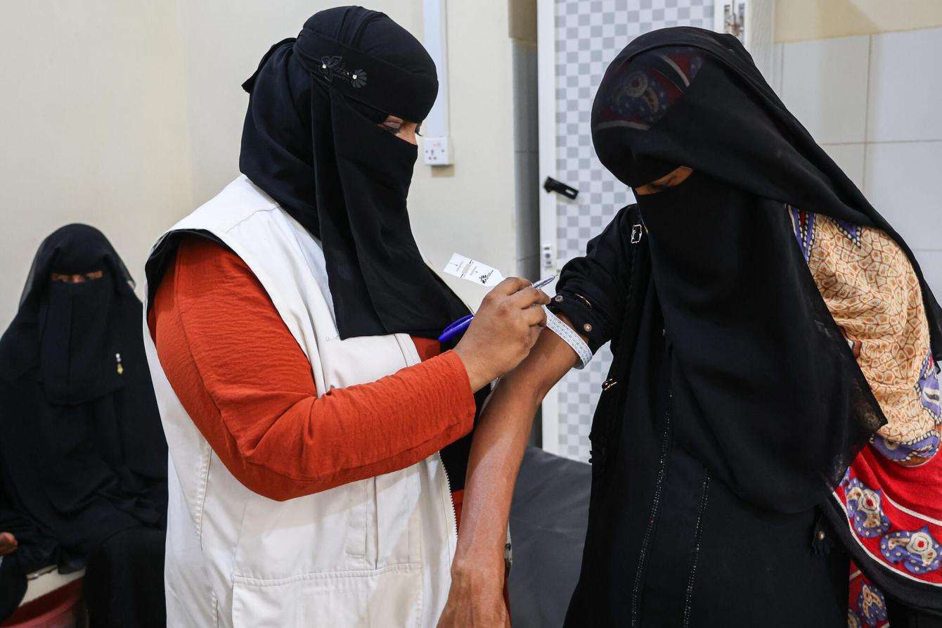 MSF staff member measures the mid-upper arm circumference of a woman at Abs Hospital in Yemen.