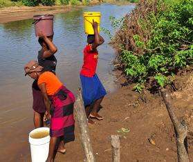 Women fetch wate from a river in Zimbabwe.