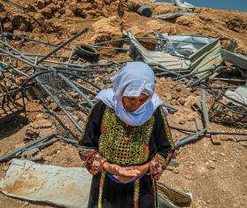 A woman in traditional Palestinian dress in front of the ruins of her home after it was demolished by Israeli forces in Masafer Yatta, West Bank.