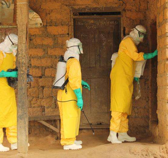 An MSF Ebola outreach team enters a house to check on a patient in Foya, Liberia.
