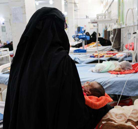 The mother of an MSF patient sits on a hospital bed in Yemen.