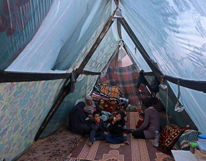 Displaced Palestinians inside a tent in Rafah, Gaza.