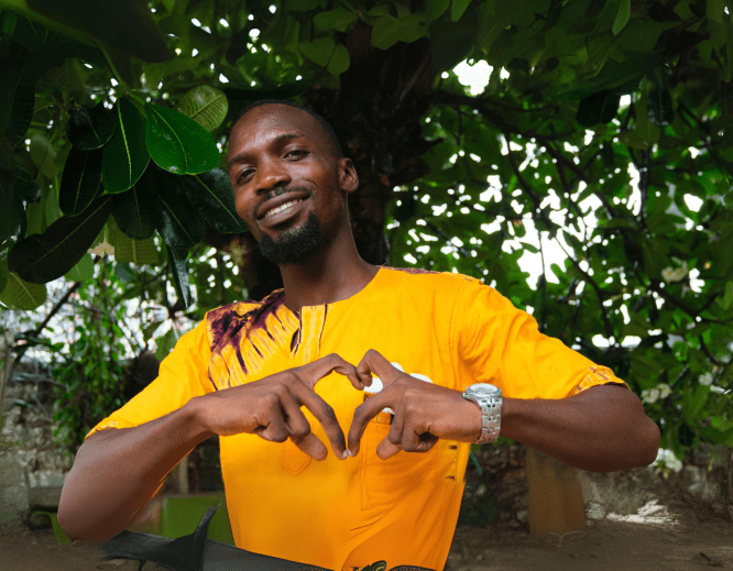 A man making a heart symbol with his hands in Kenya.