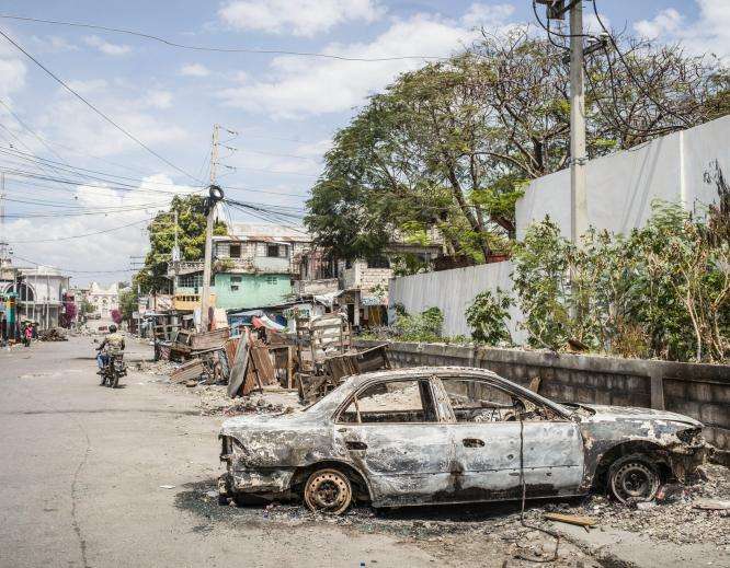 The burned husk of a car on the streets of Port-au-Prince, Haiti. 