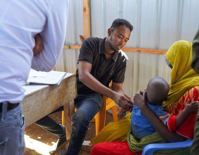 Health care worker measuring arm circumference of a child in Baidoa, Somalia