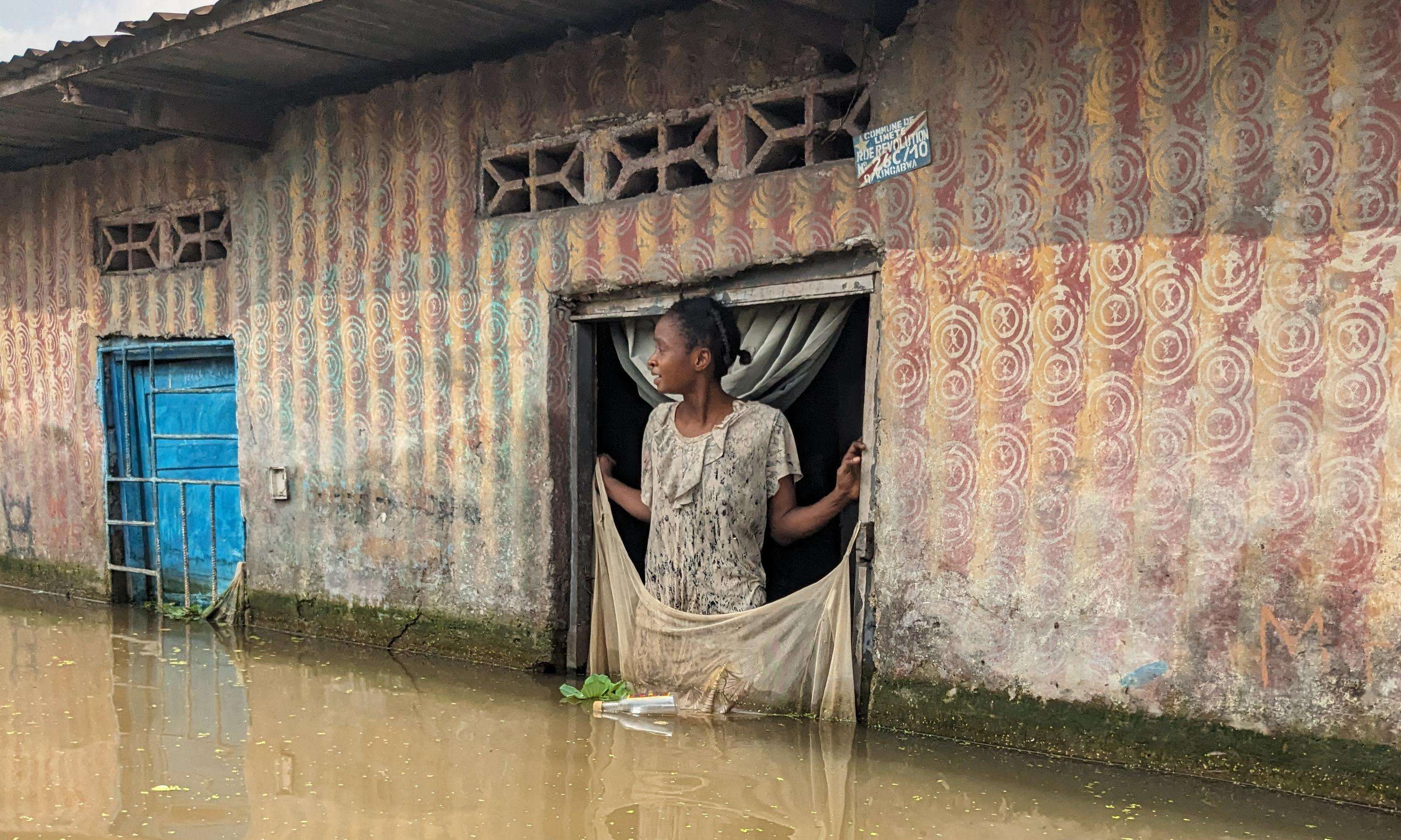 A woman looks out from a window during a flood in Democratic Republic of Congo.