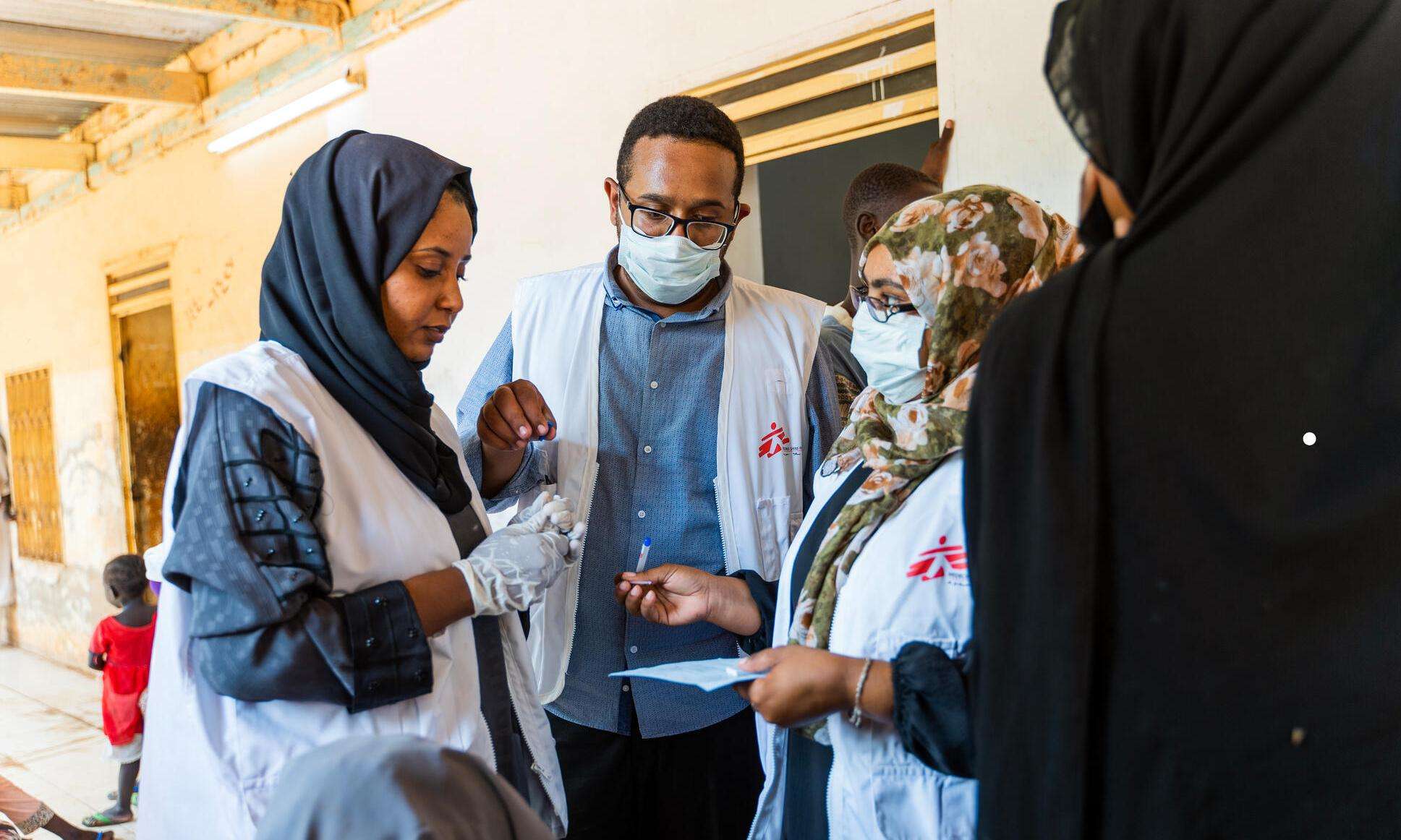 Three MSF medical staff discuss patients at a mobile clinic in Wad Madani, Sudan.