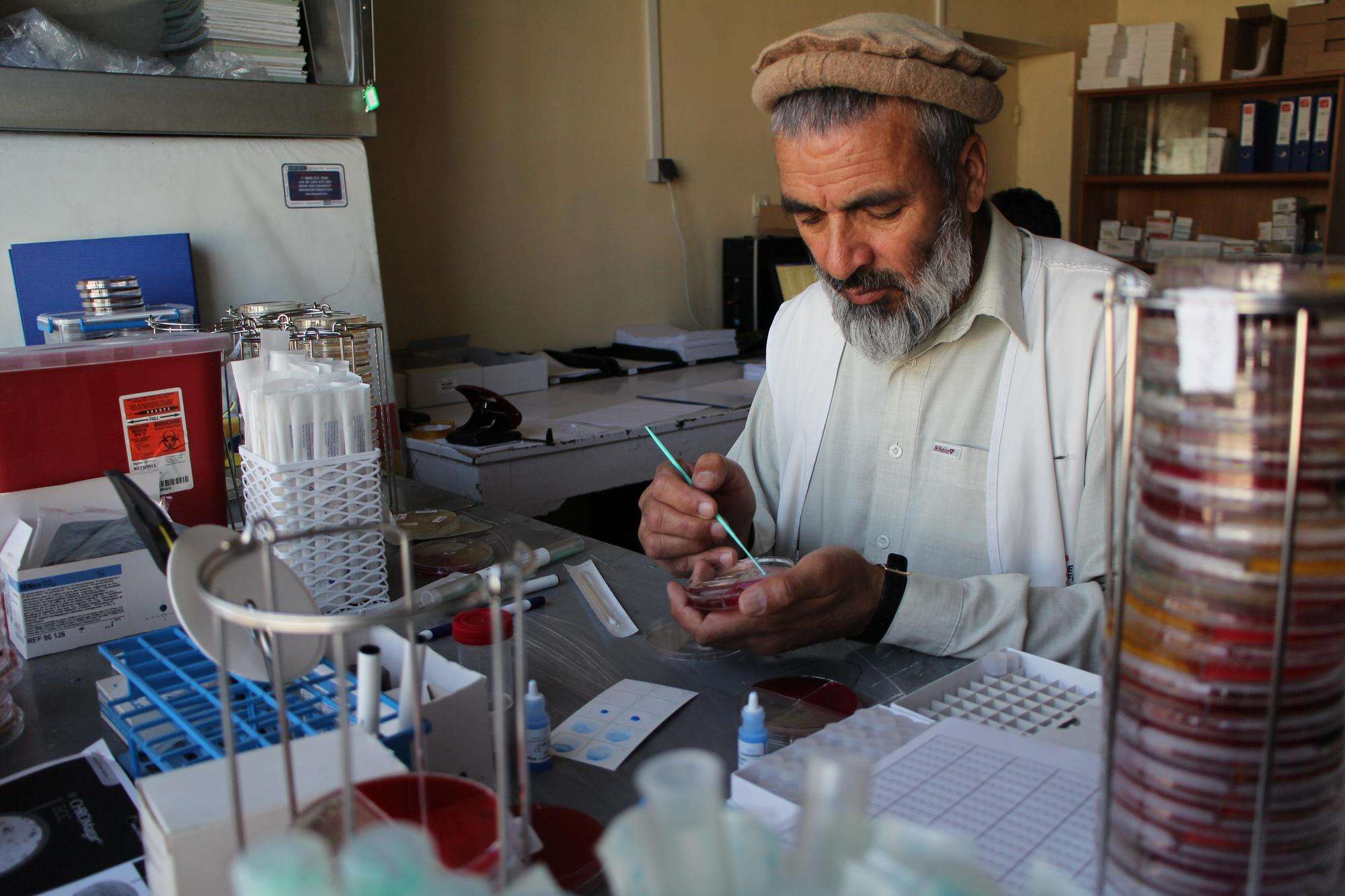 Dr Wardak Abdul Qayoum assists the expat microbiologist in supervising the team and carrying out isolation, identification and sensitivity testing of the 3000 bacterial strains expected. He uses a plastic loop to take a colony of bacteria from the culture plate.