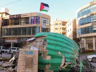 Damage to a watermelon construction in a roundabout in Jenin, next to a Palestinian flag.