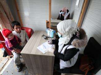 An MSF nurse talks with a young boy Northwest Syria