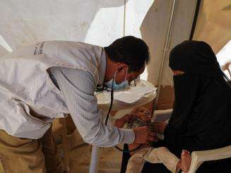 MSF doctor Abdul Malik examining one-year-old baby