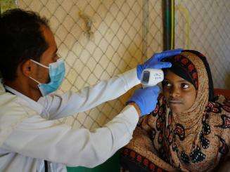 MSF nurse Yaseem checks the temperature of a patient
