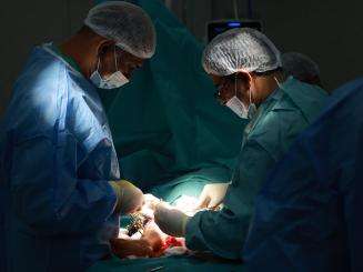 Doctors perform surgery on a patient in a dark room at Nasser Hospital in Gaza