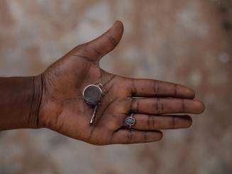 An open hand holding a whistle for protection from sexual violence in Nigeria.