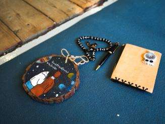 A notebook, prayer beads, and wooden disk carried by a migrant in the Mediterranean Sea. 