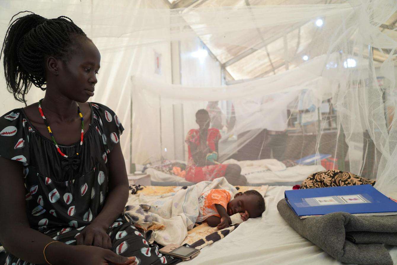 A mother watches over her young child who has been admitted to the pediatric ward