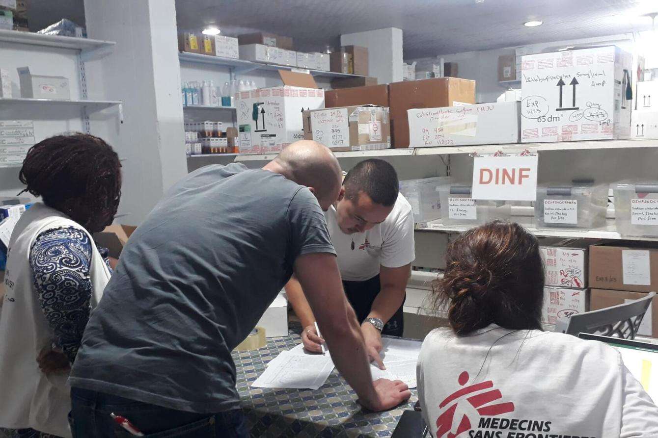 Four MSF staff reviewing documents on a table. 