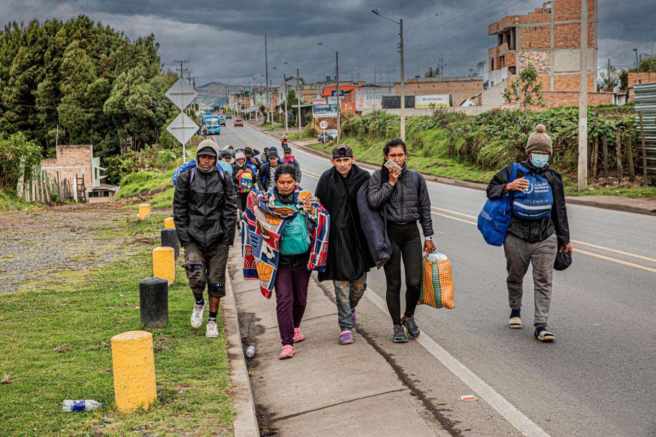 A group of migrants walk along the Pan-American highway in Nariño, Colombia