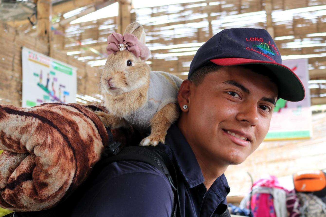 Fernando, a migrant from Bolivia, with his pet rabbit Sarita in Peru.