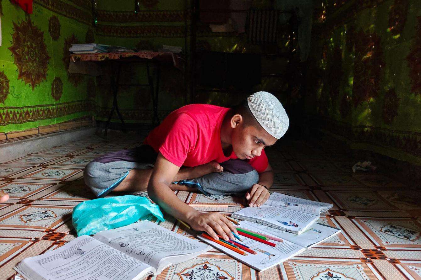 Muhammad, who is learning Arabic, does his homework in Cox's Bazar.