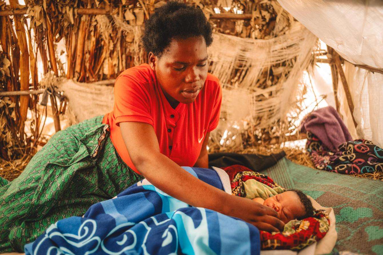 Gisèle looks at her daughter Justine in her tent in DR Congo.