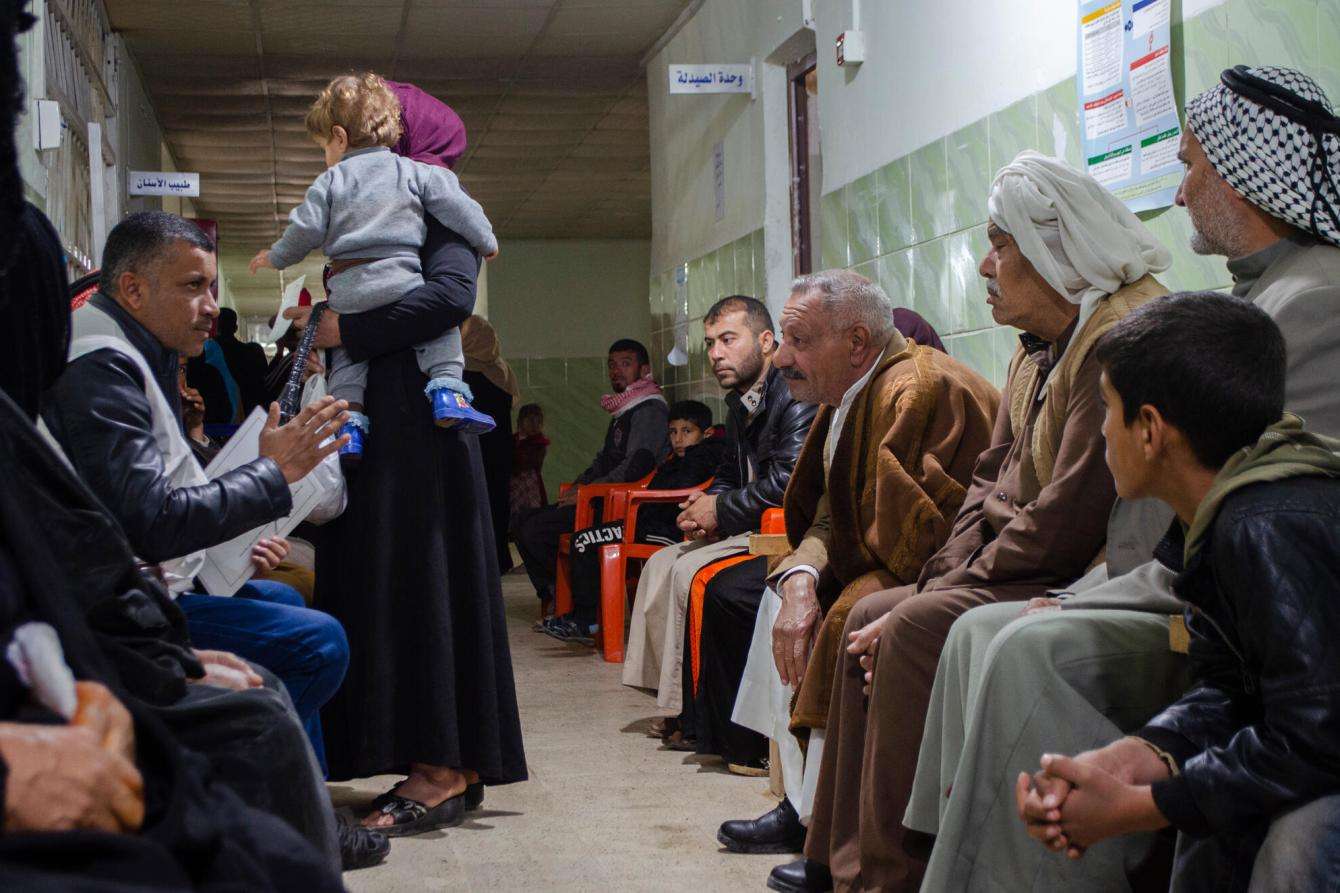 An MSF health promoter runs an education session about non-communicable diseases in the waiting room of Hawija's primary health care center.