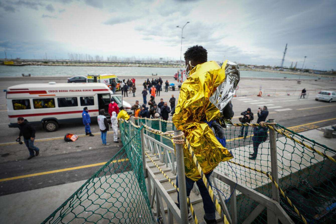 Migrants rescued from a boat in distress in the Mediterranean disembark.