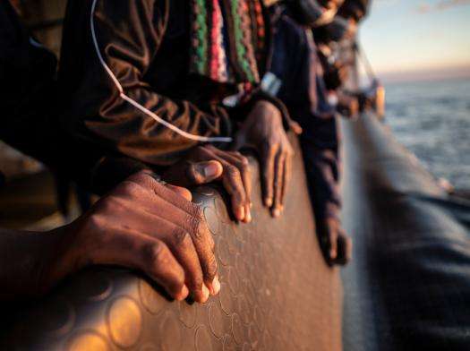 Hands of migrants on Mediterranean rescue ship