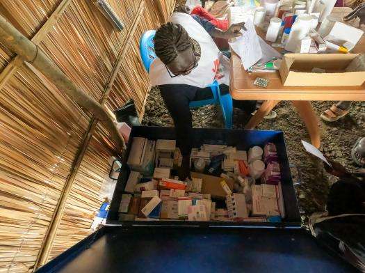 A person looks into a box of medicine at the MSF mobile clinic in Zero Transit Centre in Renk, Upper Nile State.