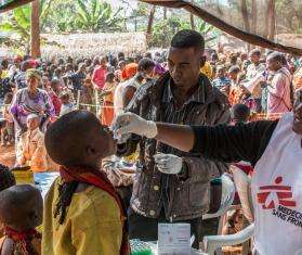MSF Staff administrate an oral vaccine to a boy at the Nyaragusu refugee camp.