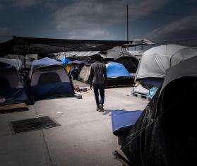 A man walks through the "Senda de Vida" migrant shelter in Reynosa, Mexico, at the US southern border. Hundreds of families relocated to this shelter in May 2022 after a camp that had formed in a public plaza was evacuated and cleared away. At the time, two thousand people were living in the camp, including hundreds of children.