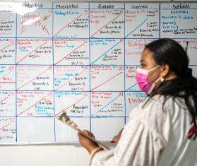 An MSF staff member at the clinic in San Pedro Sula, Honduras, stands before a whiteboard.