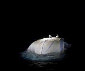 A capsized boat in the Central Mediterranean Sea at night.