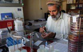 Dr Wardak Abdul Qayoum assists the expat microbiologist in supervising the team and carrying out isolation, identification and sensitivity testing of the 3000 bacterial strains expected. He uses a plastic loop to take a colony of bacteria from the culture plate.